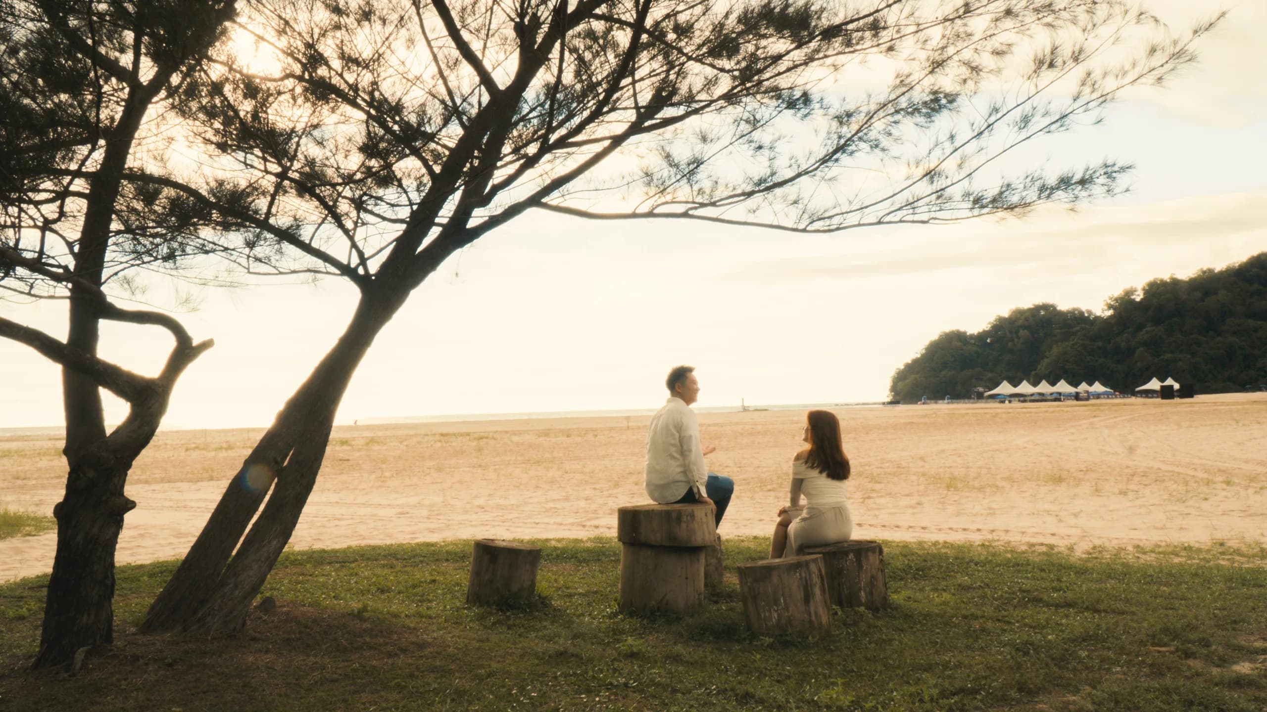 Ian and Phy sitting by the wide beach at Rasa Ria
