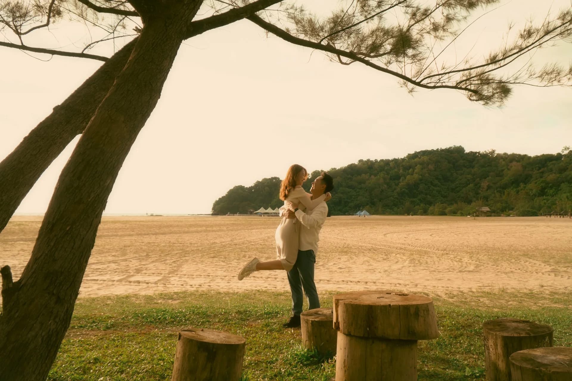 Ian lifting Phy beneath a tree in the golden light at Rasa Ria